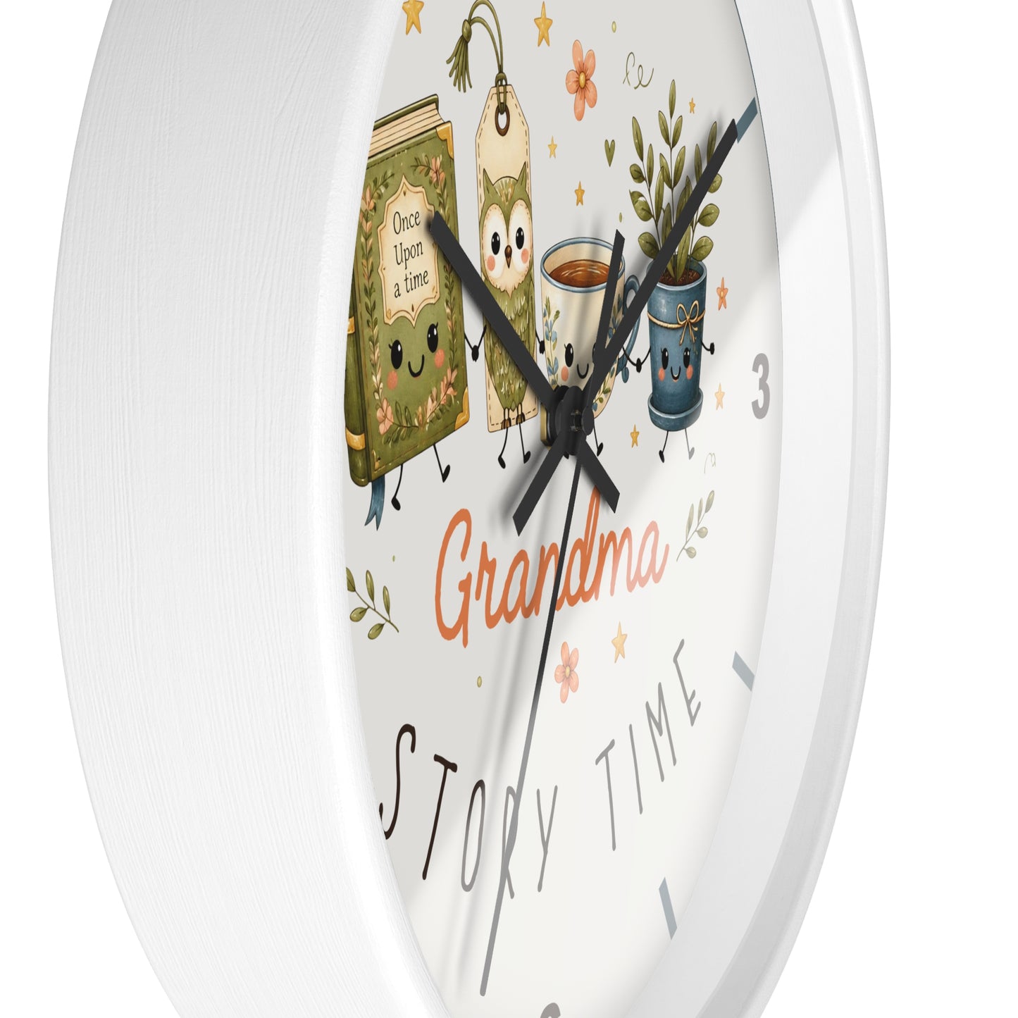 A white round wall clock with a whimsical 'Grandma Story Time' illustration. The clock face features cute cartoon characters including a green book, a teapot, and a potted plant, along with black hands and black numbers.