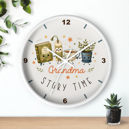 A round wall clock with a white frame and a whimsical 'Grandma Story Time' illustration on the dial, styled on a light wall above a wooden surface with small potted plants.