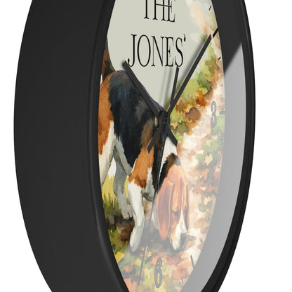 A round wall clock with a black frame and a printed watercolor-style face showing a tricolor dog on a path, with the text 'THE JONES' at the top.