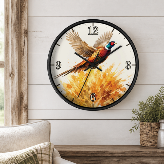 A round wall clock with a black frame hangs on a white shiplap wall above a wooden console table. The clock face features a colorful pheasant bird in flight over a golden floral burst.