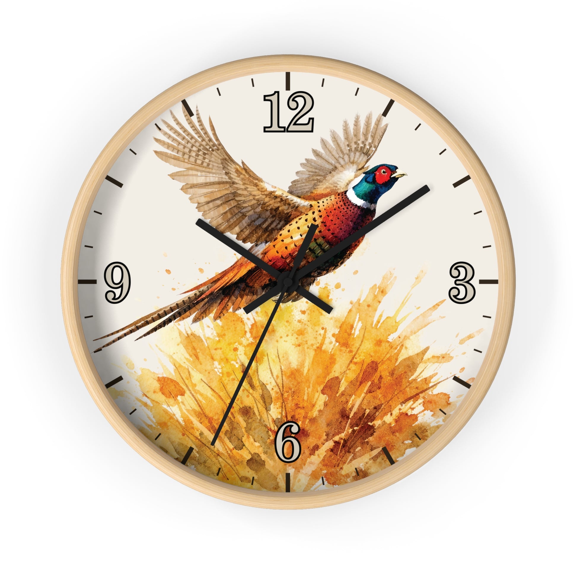 A round wall clock with a light natural wood frame and a printed bird artwork on the face. The design shows a pheasant in flight above a warm orange and yellow brushstroke pattern, with black numerals and hands on a white background.