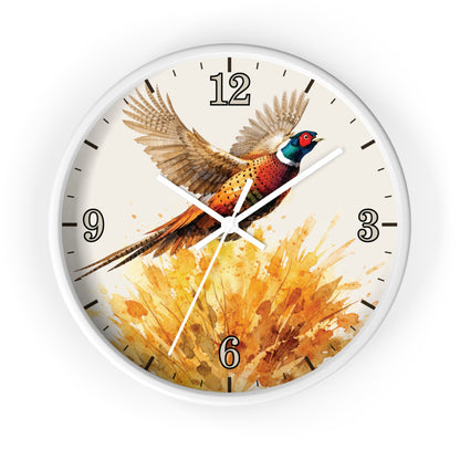 A round wall clock with a white frame and a printed design of a pheasant bird flying over a golden watercolor splash. The clock face is off-white with black Arabic numerals and simple black hour markers, and the clock hands are white.