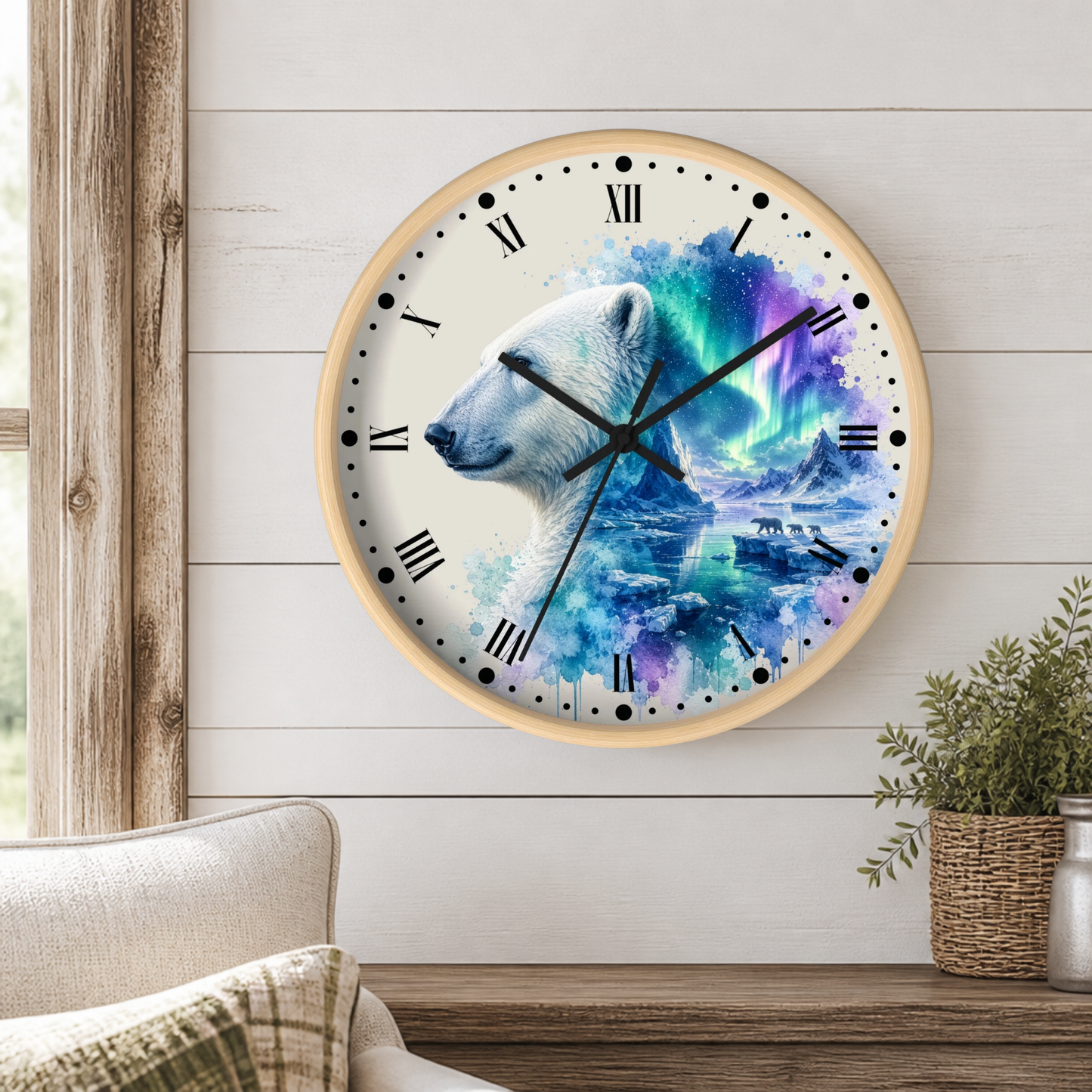 A round wall clock with a light wood frame hangs on a white shiplap wall above a wooden table. The clock face features a polar bear illustration blending into a colorful aurora design in blue, purple, and green tones.