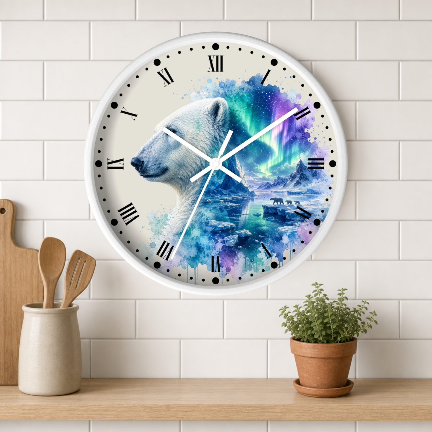A round wall clock with a white frame and Roman numerals, featuring a polar bear illustration over a vivid blue, purple, and teal aurora design. The clock is mounted on a white subway tile wall above a wooden shelf with a small potted plant and wooden utensils.
