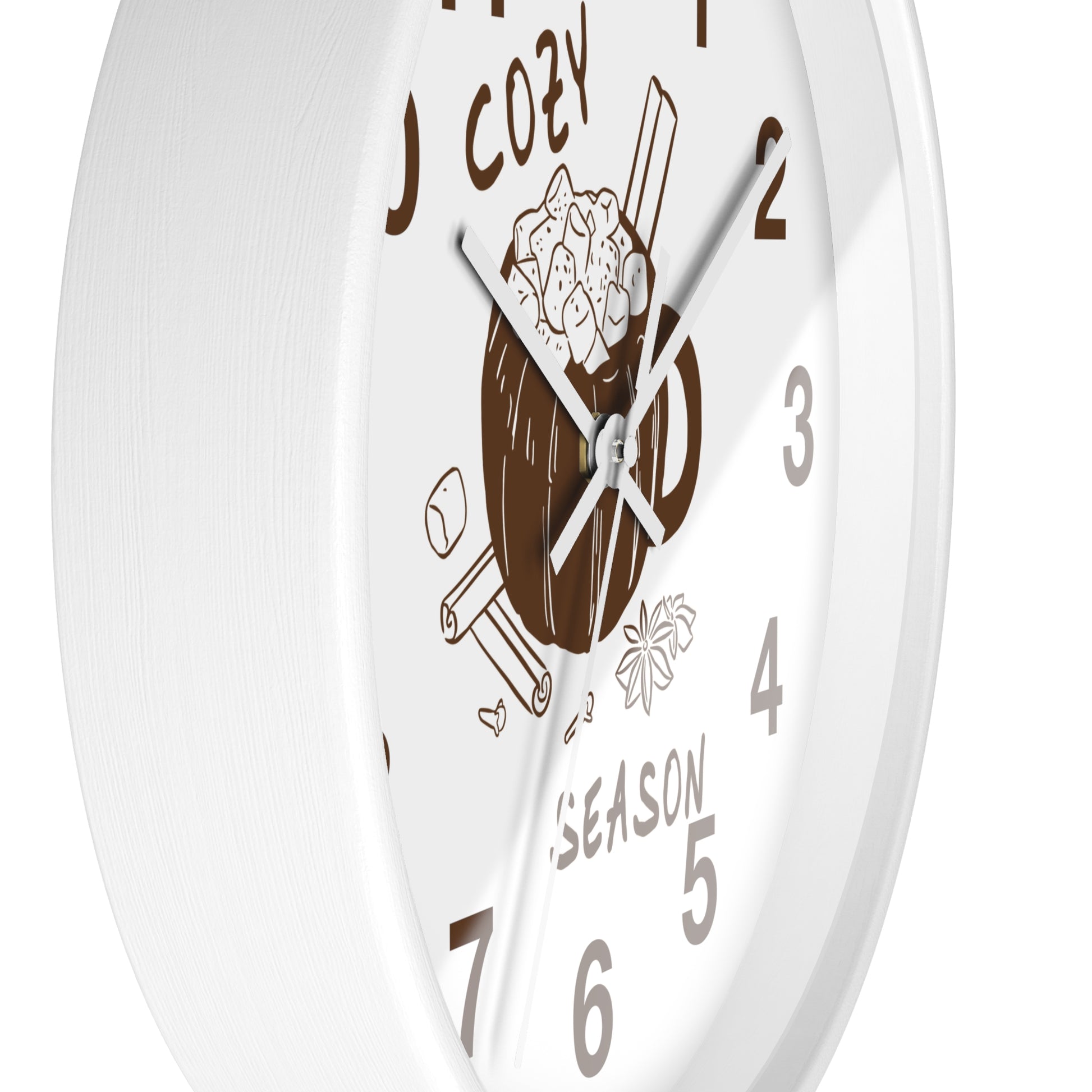 A white round wall clock with a cozy holiday design, featuring a brown mug filled with hot cocoa and cinnamon sticks, with the words 'COZY' and 'SEASON' on a clean white background.