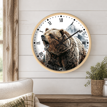 A round wall clock with a light wood frame hangs on a white shiplap wall above a wooden table. The clock face features a detailed graphic of a roaring brown bear in front of a mountain landscape, with black Roman numerals and hands.