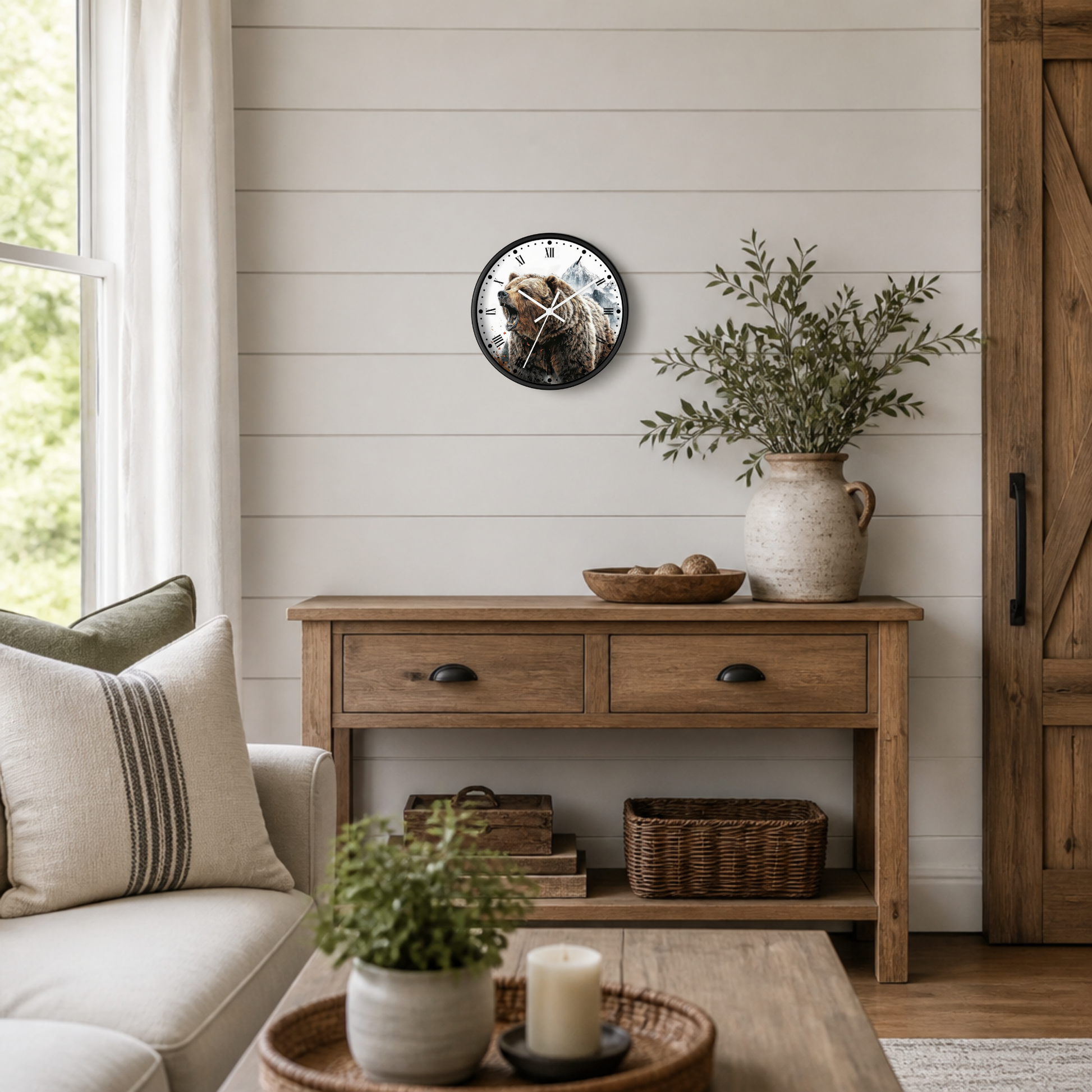 A round wall clock with a rustic illustration of a bear hanging on a white shiplap wall above a wooden console table in a styled living room.