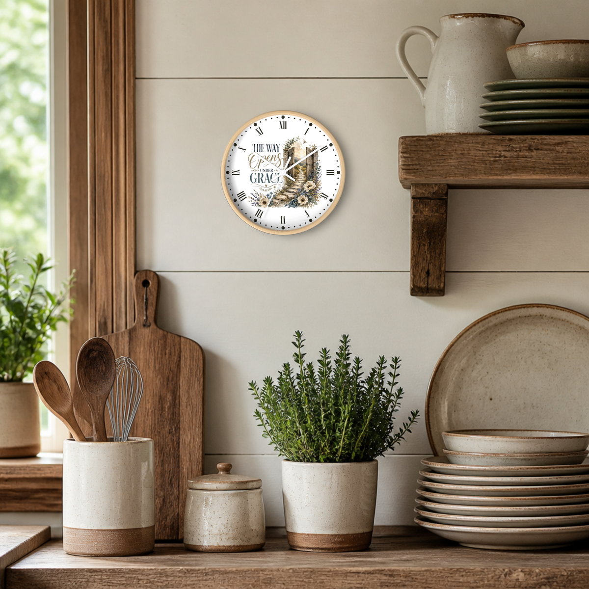 A round wall clock with a rustic wood frame and a white face featuring the text 'THE Way Opens Under Grace ' and an illustration of a cowboy boot, styled on a beige shiplap wall in a rustic kitchen setting