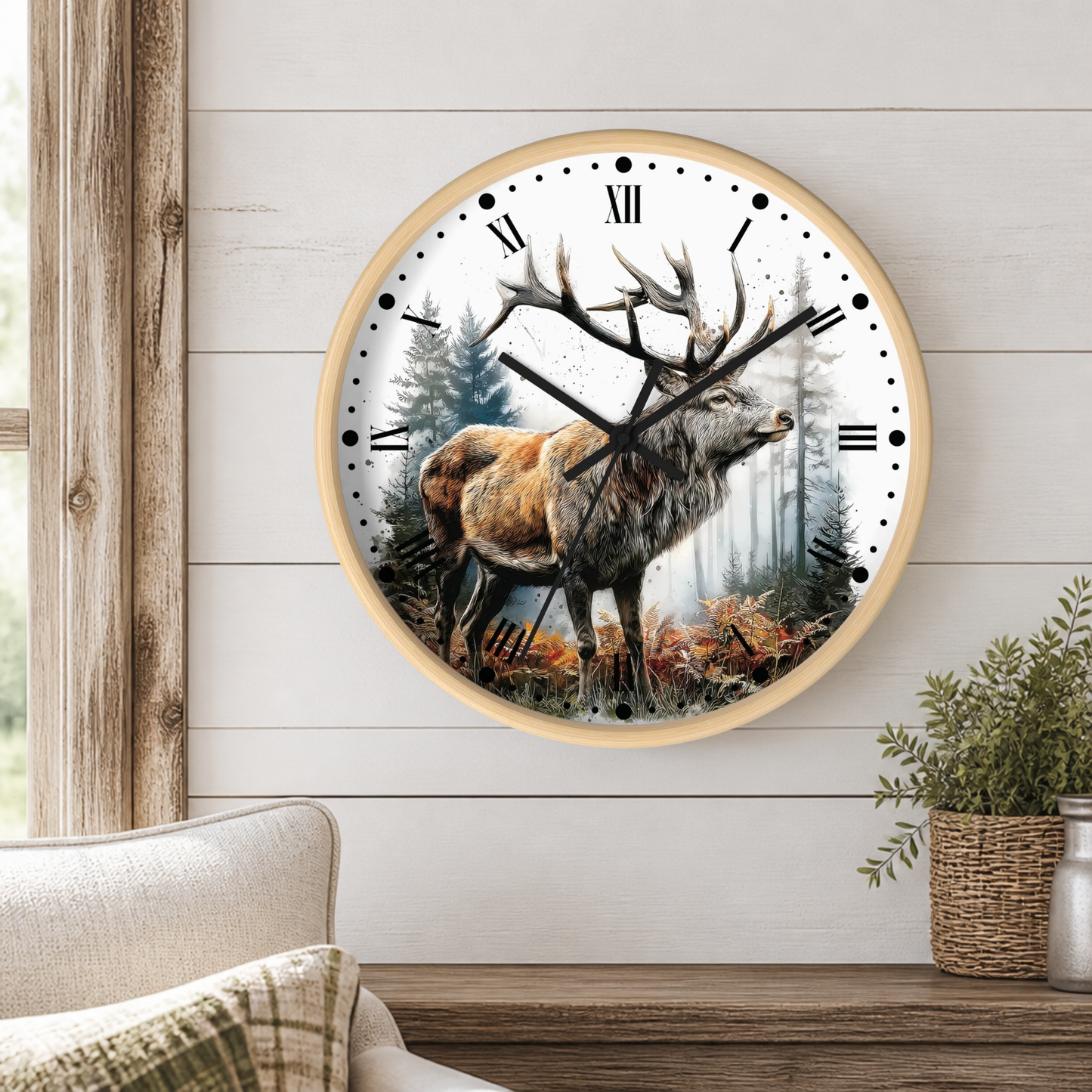 A round wall clock with a light wood frame hangs on a white shiplap wall above a wooden mantel. The clock face features a detailed illustration of a stag with large antlers in a misty forest.