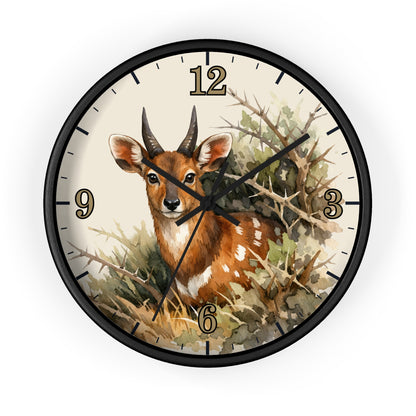 Round wall clock with a black frame and a watercolor-style illustration of a brown deer among branches and foliage on the clock face, with black numerals and hands on a white background.