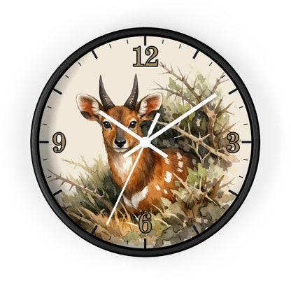 A round wall clock with a black frame and a printed illustration of a brown antelope deer among branches and foliage. The clock face is cream-colored with black Arabic numerals and white clock hands.