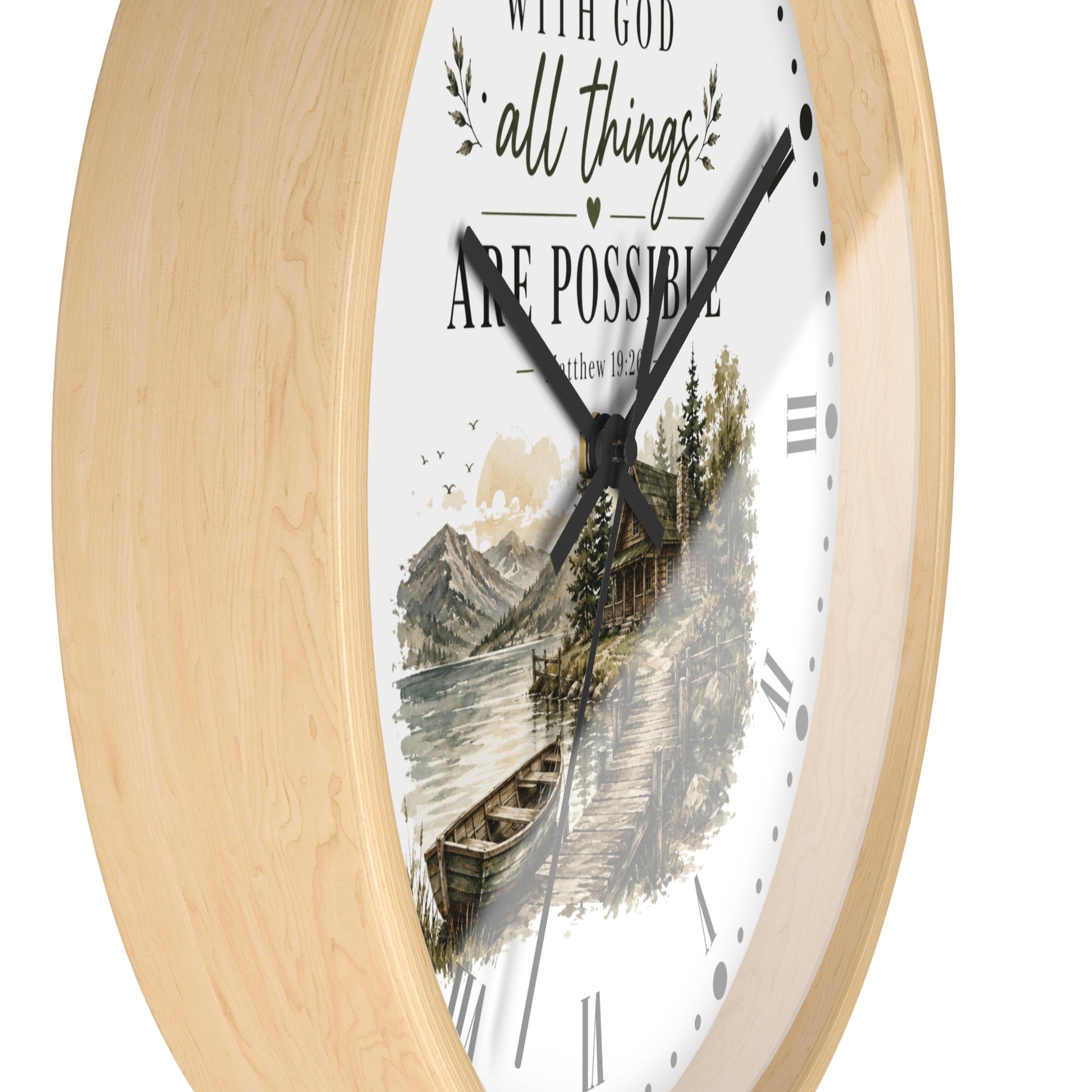 A round wall clock with a light natural wood frame and a white face featuring a scenic lake and cabin illustration, along with the text 'WITH GOD all things ARE POSSIBLE' and 'Matthew 12:13'.