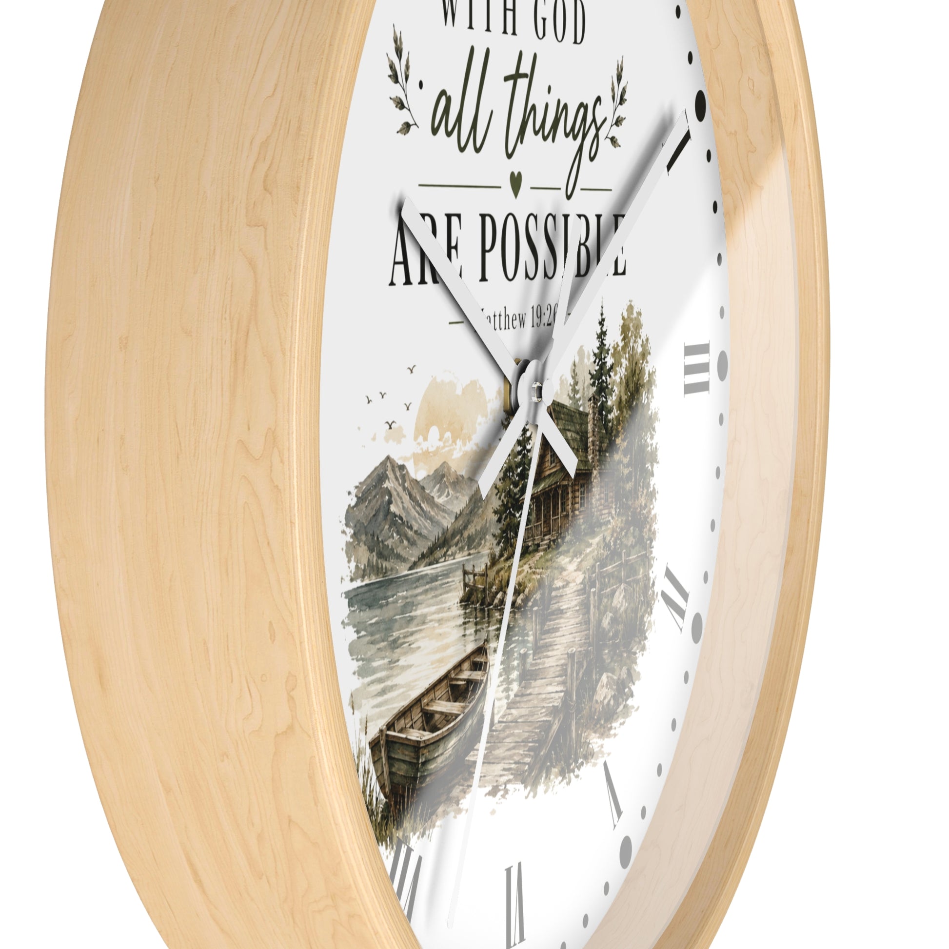 A round wall clock with a light natural wood frame and a white dial featuring a scenic mountain lake illustration and the text 'WITH GOD all things ARE POSSIBLE' and 'Romans 8:28'.
