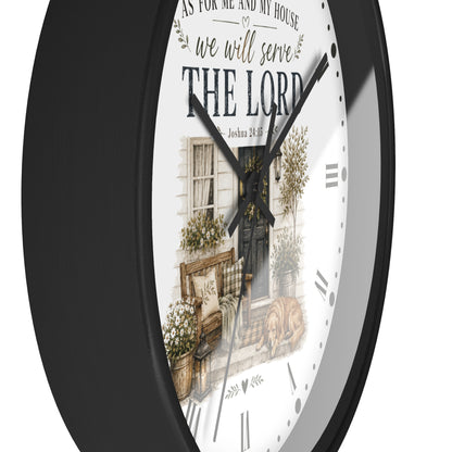 A round wall clock with a black frame and a white face featuring a rustic illustration of a front porch and the text 'AS FOR ME AND MY HOUSE we will serve THE LORD'.