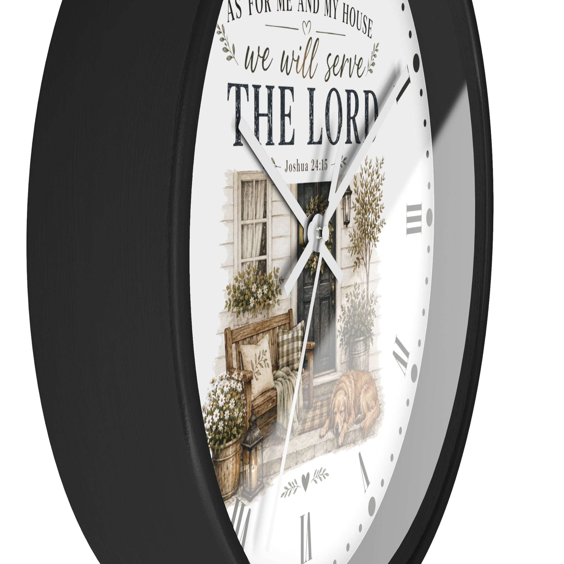 A round wall clock with a black frame and a white face featuring a rustic illustration of a house porch and the text 'we will serve THE LORD' and 'As for me and my house, so be it.'.