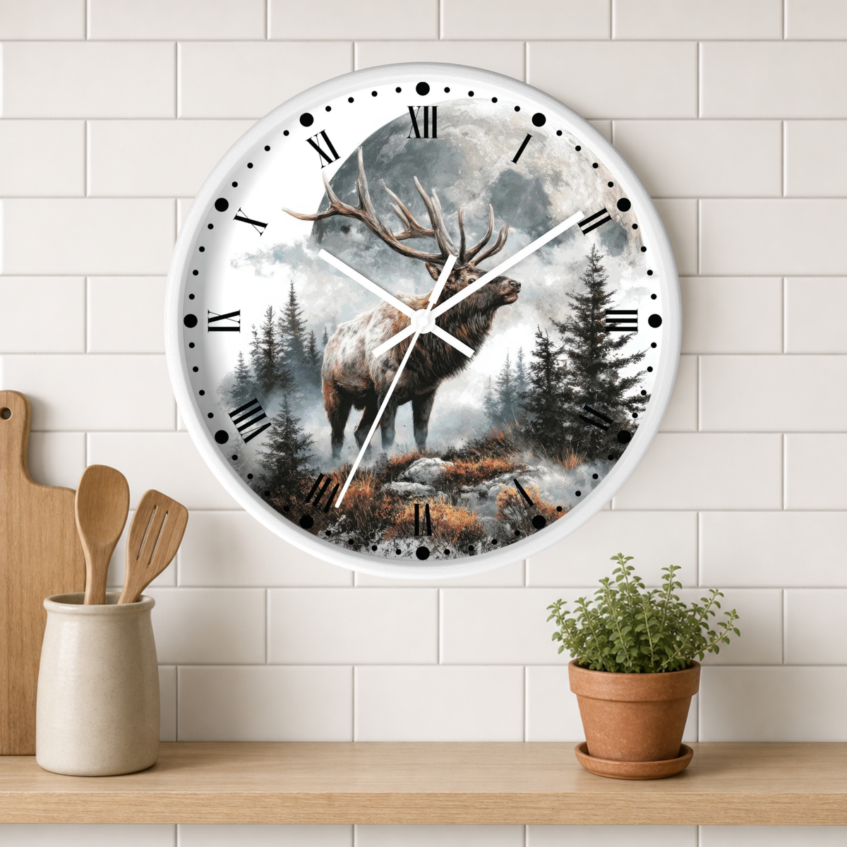 A round wall clock with a white frame and a scenic print of a stag in a misty forest, mounted on a white subway tile wall above a wooden shelf with a small potted plant and wooden utensils.