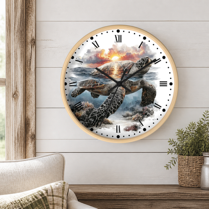 A round wall clock with a light wood frame hangs on a white shiplap wall. The clock face features a detailed illustration of a sea turtle swimming through ocean water toward a sunset, with black Roman numerals and hands.
