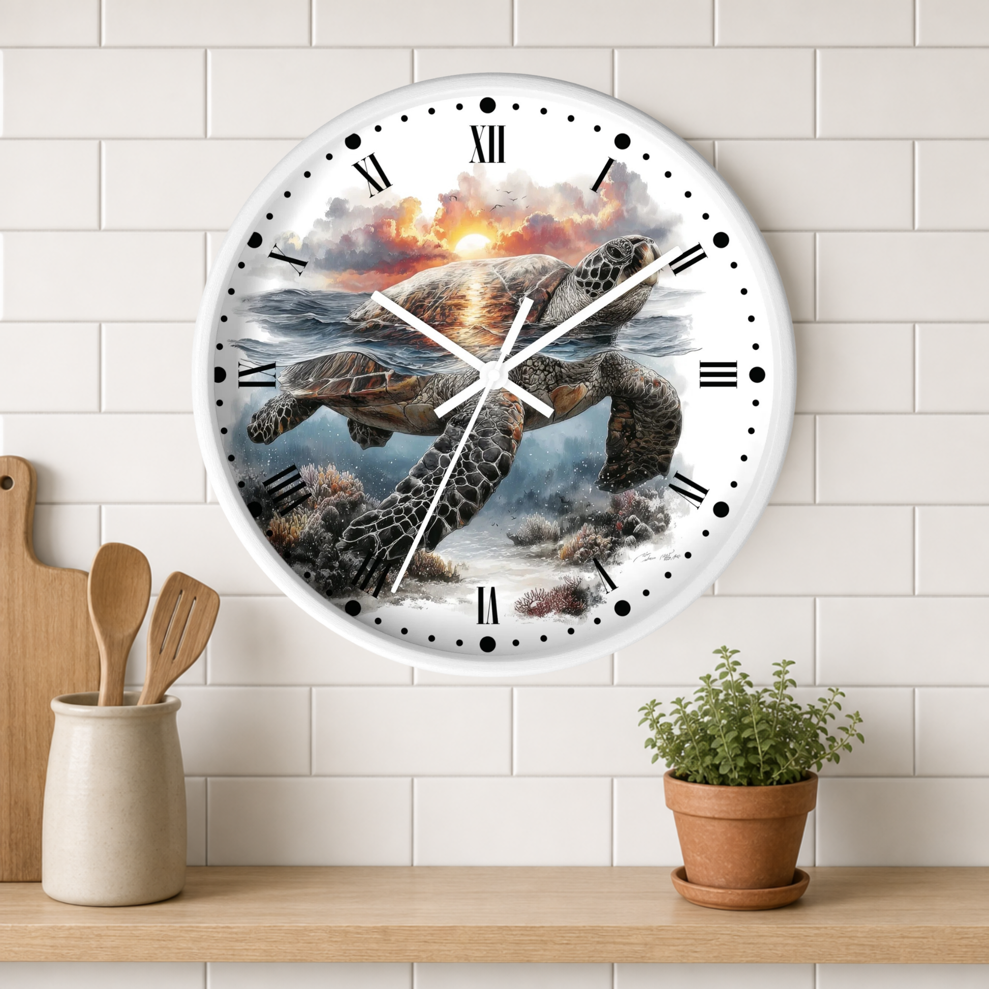 A round wall clock with a sea turtle sunset illustration, mounted on a white subway tile wall above a wooden shelf with kitchen utensils and a potted plant.