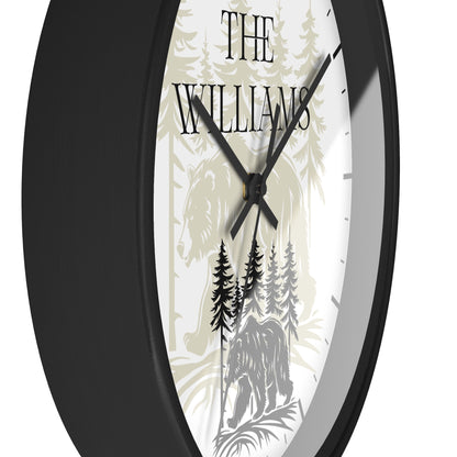 A close-up of a round wall clock with a black frame and a white face featuring a forest illustration, a horse, and the text 'THE WILLIAMS'.