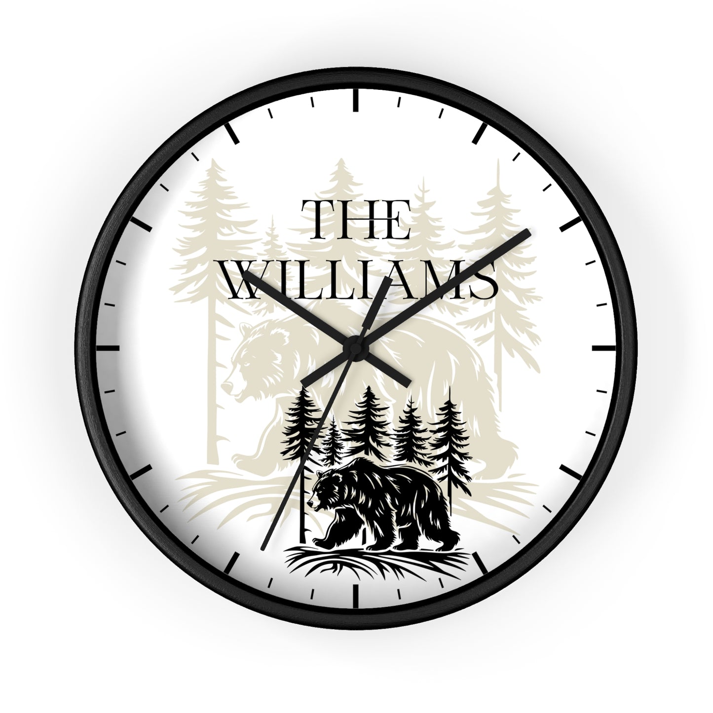 A round wall clock with a black frame and black hands, featuring a white face printed with a black bear silhouette, pine trees, and the text 'THE WILLIAMS' in black serif lettering.