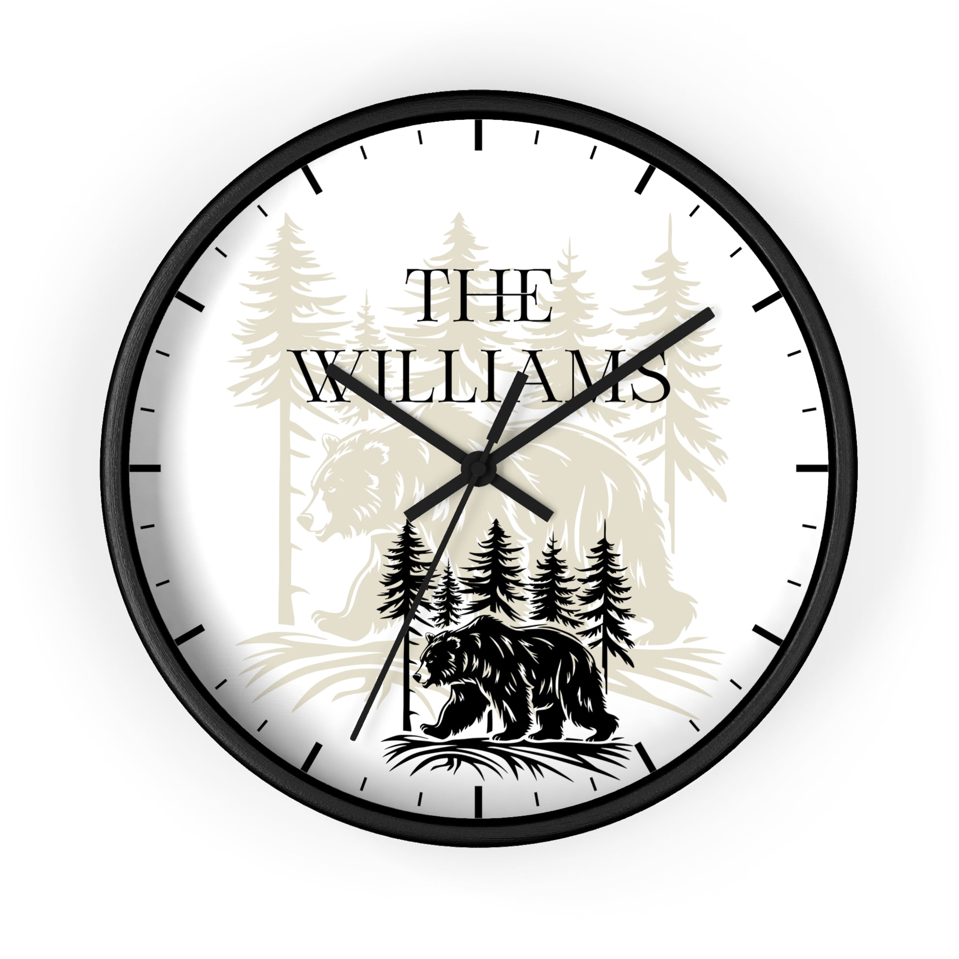 A round wall clock with a black frame and black hands, featuring a white face printed with a black bear silhouette, pine trees, and the text 'THE WILLIAMS' in black serif lettering.