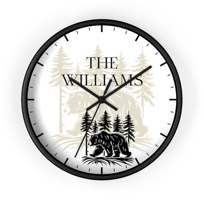 A round wall clock with a black frame and black hands, featuring a white face printed with a black bear silhouette, pine trees, and the text 'THE WILLIAMS' in black serif lettering.