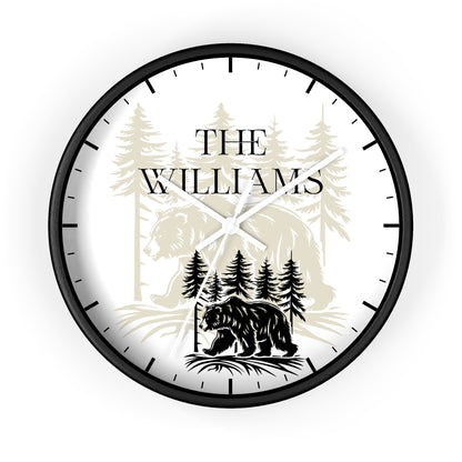 A personalized round wall clock with a black frame and black hands, featuring a white face with a black bear silhouette, pine trees, and the text 'THE WILLIAMS'.