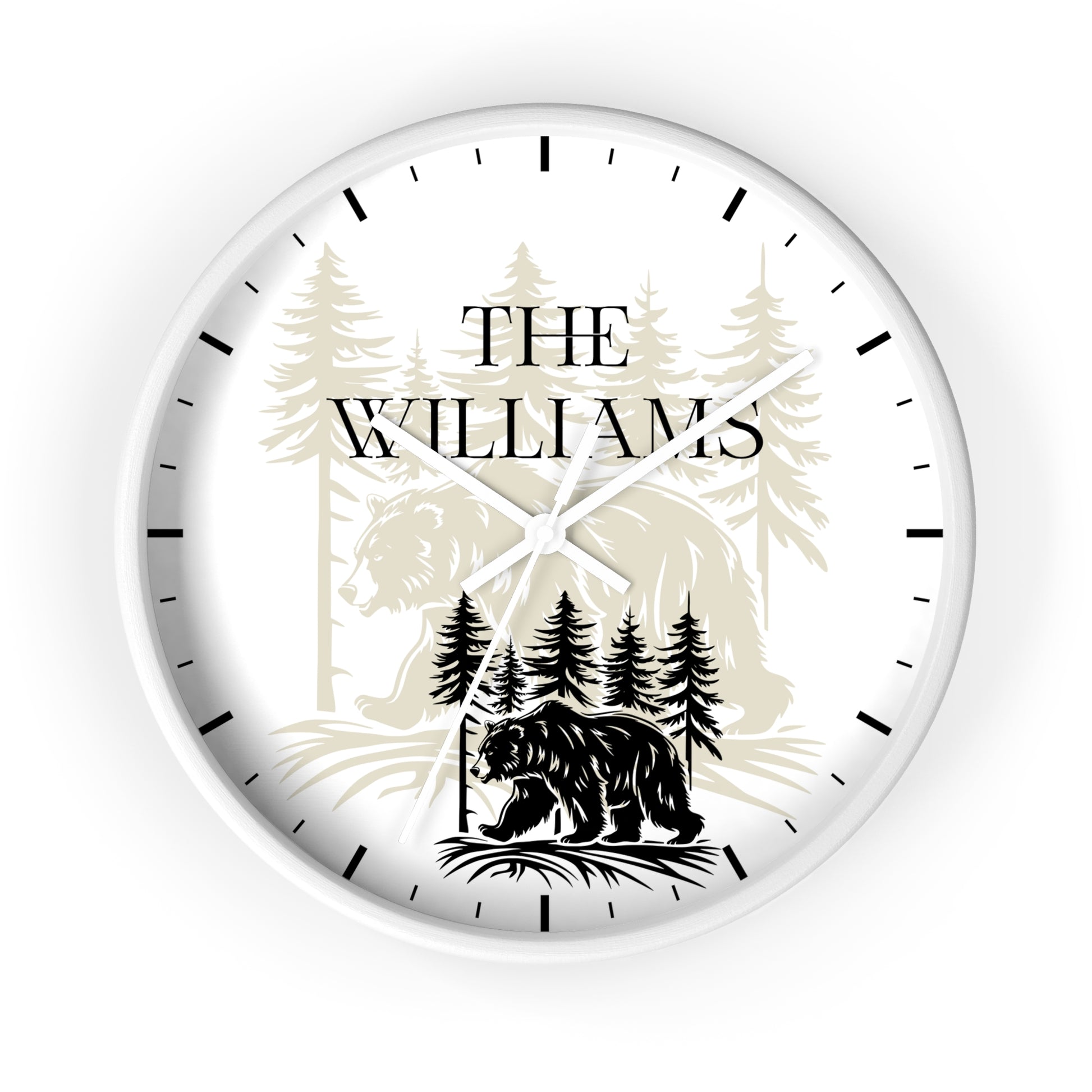 A personalized round wall clock with a white face, black hands, and black hour markers. The center features a custom graphic with the text 'THE WILLIAMS' above a black bear silhouette and pine tree forest illustration.