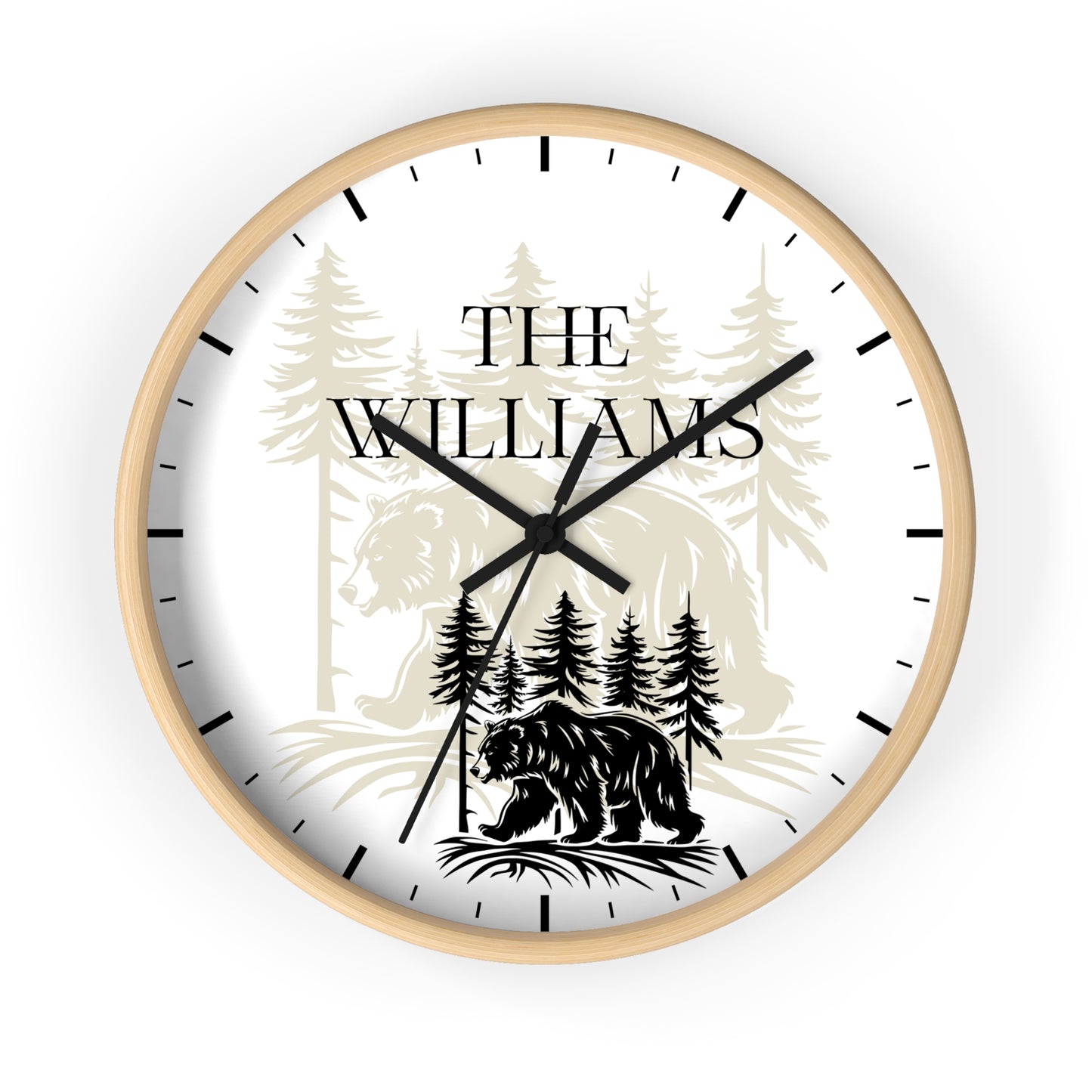 A round custom wall clock with a white face, black hands, and black hour markers. The dial features a personalized design with the text 'THE WILLIAMS' over a forest illustration, including a bear at the bottom.