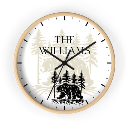 A round custom wall clock with a white face, black hands, and black hour markers. The dial features a personalized design with the text 'THE WILLIAMS' over a forest illustration, including a bear at the bottom.