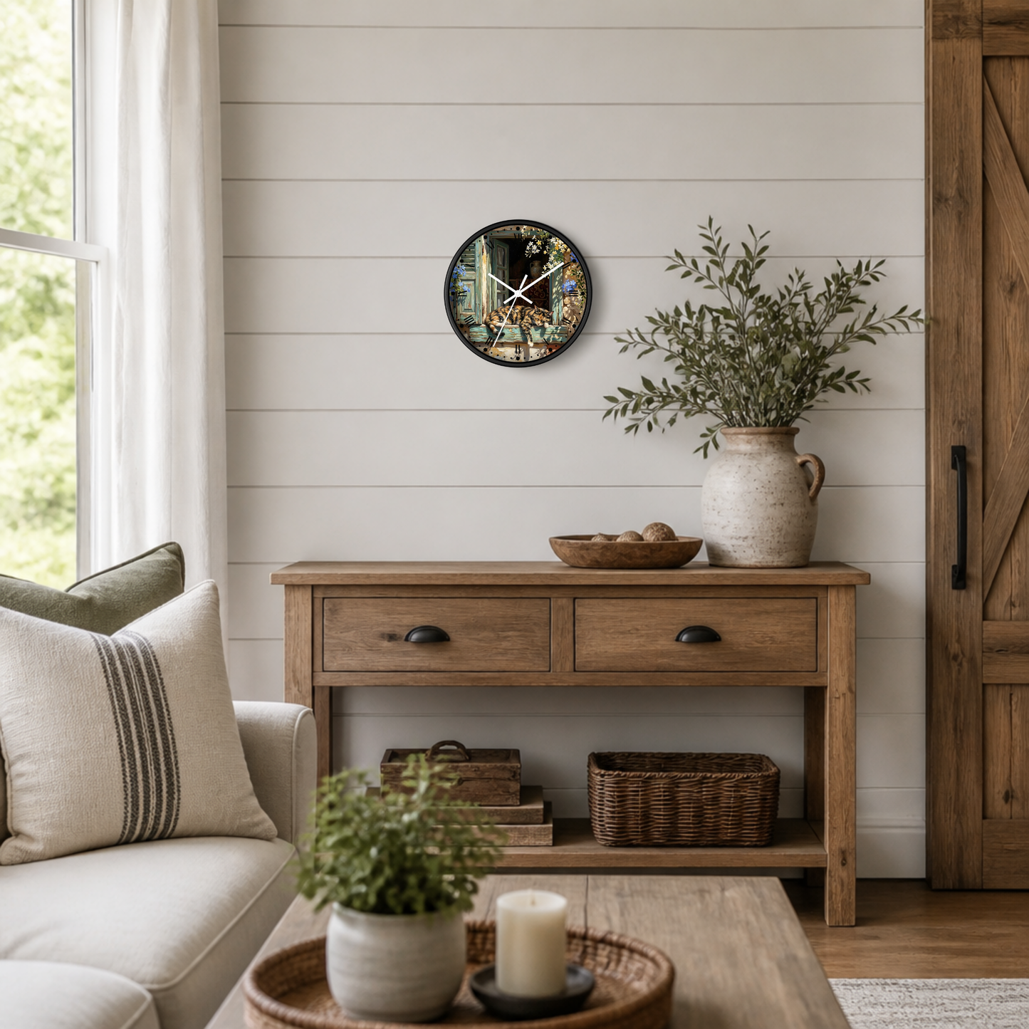 A round wall clock with a colorful cat print hangs on a white shiplap wall above a rustic wooden console table in a bright, modern farmhouse living room.