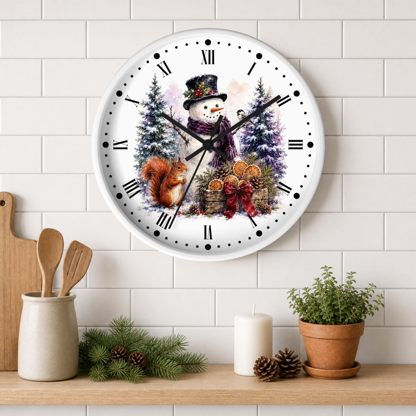 A round wall clock with a winter holiday illustration of a snowman, trees, a squirrel, and oranges, mounted on a white subway tile wall above a shelf with kitchen props.