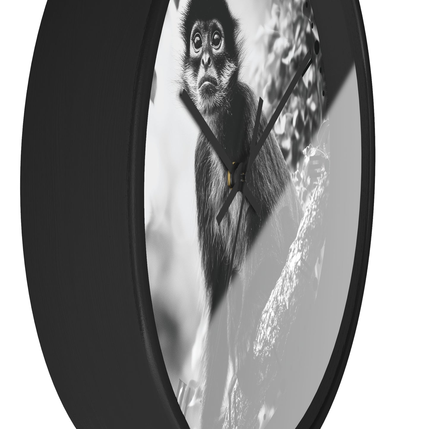 A round wall clock with a black frame and a black-and-white photographic print of a monkey on the face, shown against a plain white background.