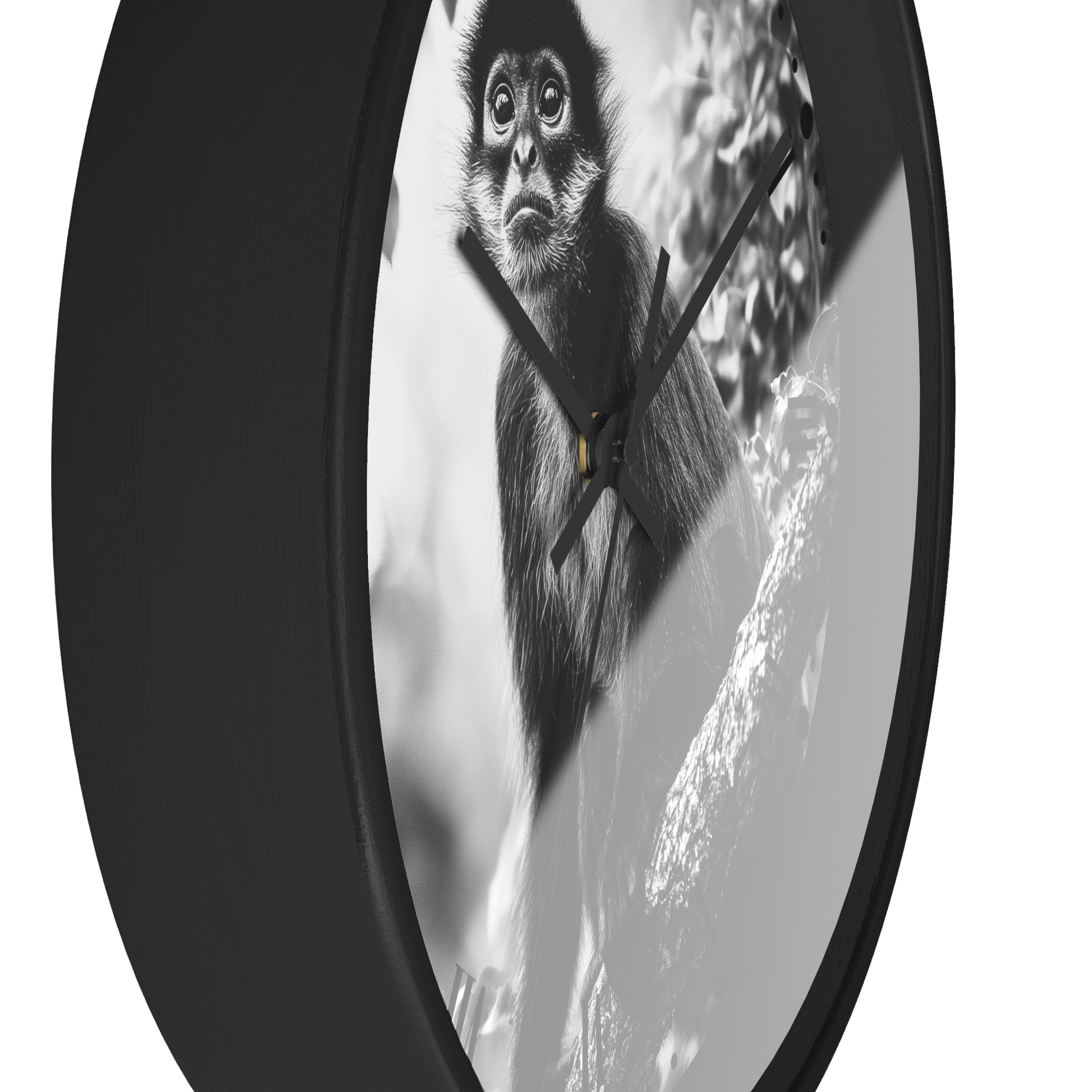 A round wall clock with a black frame and a black-and-white photographic print of a monkey on the face, shown against a plain white background.