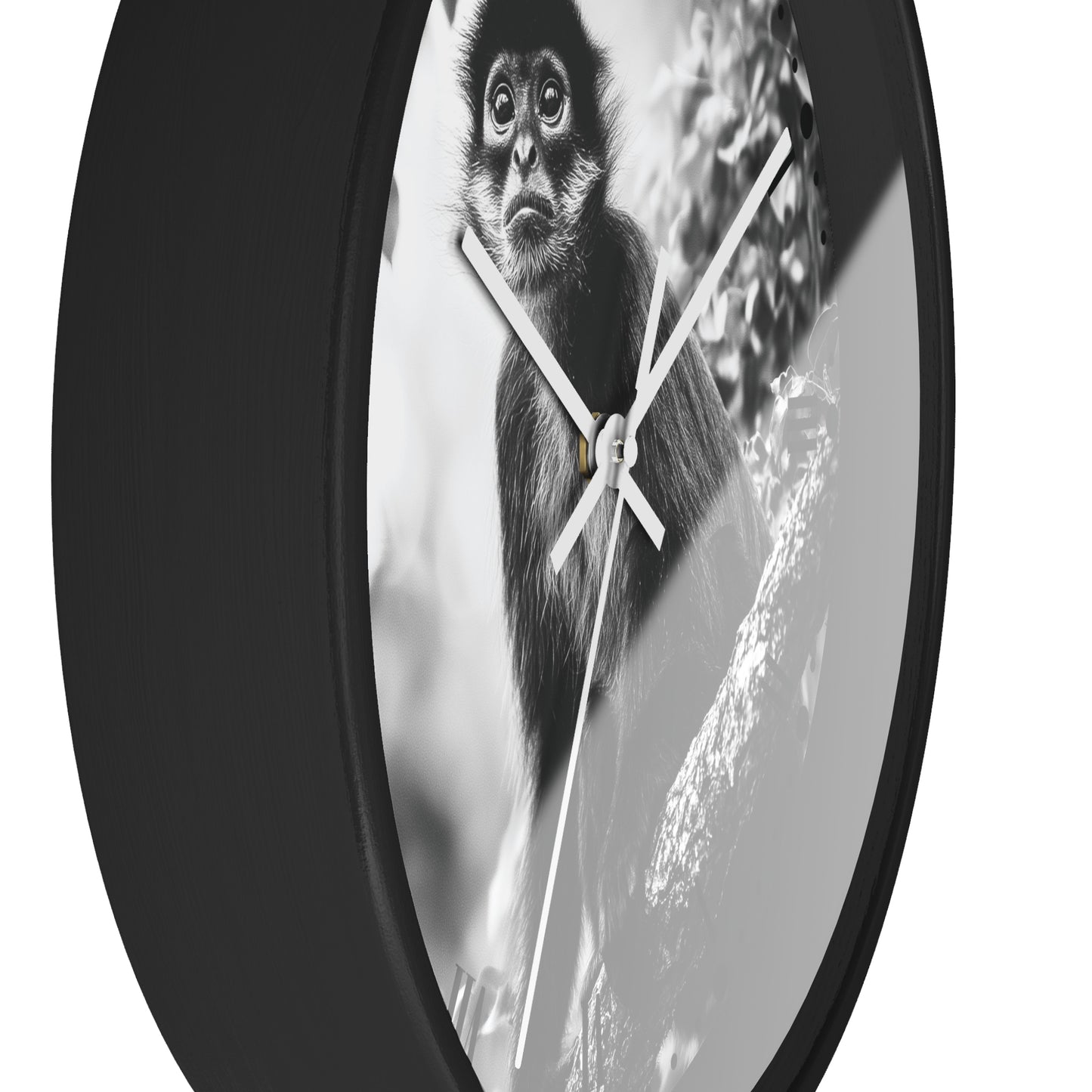 A round wall clock with a black frame and white hands, featuring a black-and-white photograph of a monkey on the faceplate, shown against a plain white background.