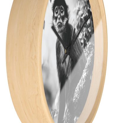 Round wall clock with a light natural wood frame and a black-and-white photographic print of a monkey on the face, shown against a plain white background.