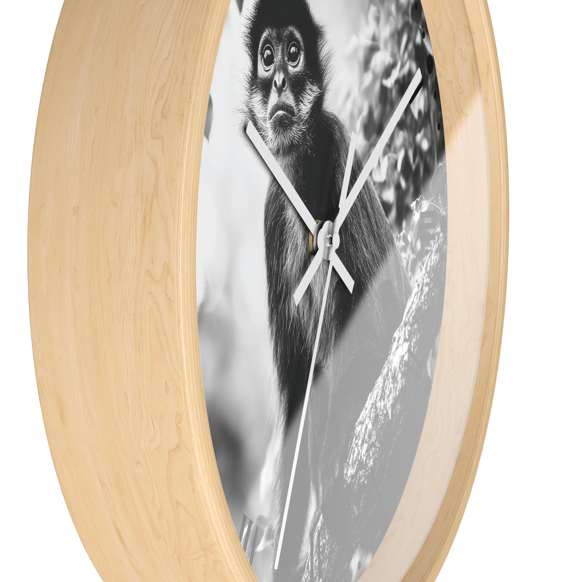 Round wall clock with a light natural wood frame and a black-and-white photographic print of a monkey on the face, with white hands.