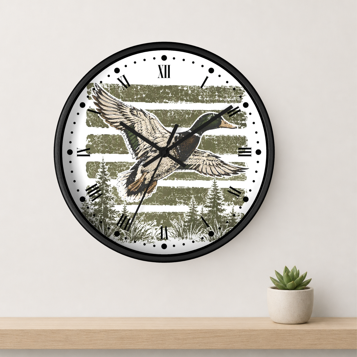 A round wall clock with a black frame and a rustic duck design, mounted on a light beige wall above a wooden shelf with a small potted succulent.