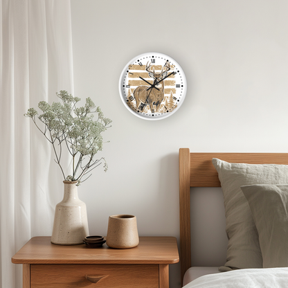A round wall clock with a white frame and a printed deer illustration hangs on a light gray bedroom wall above a wooden nightstand with a vase and candles, next to a bed with pillows.