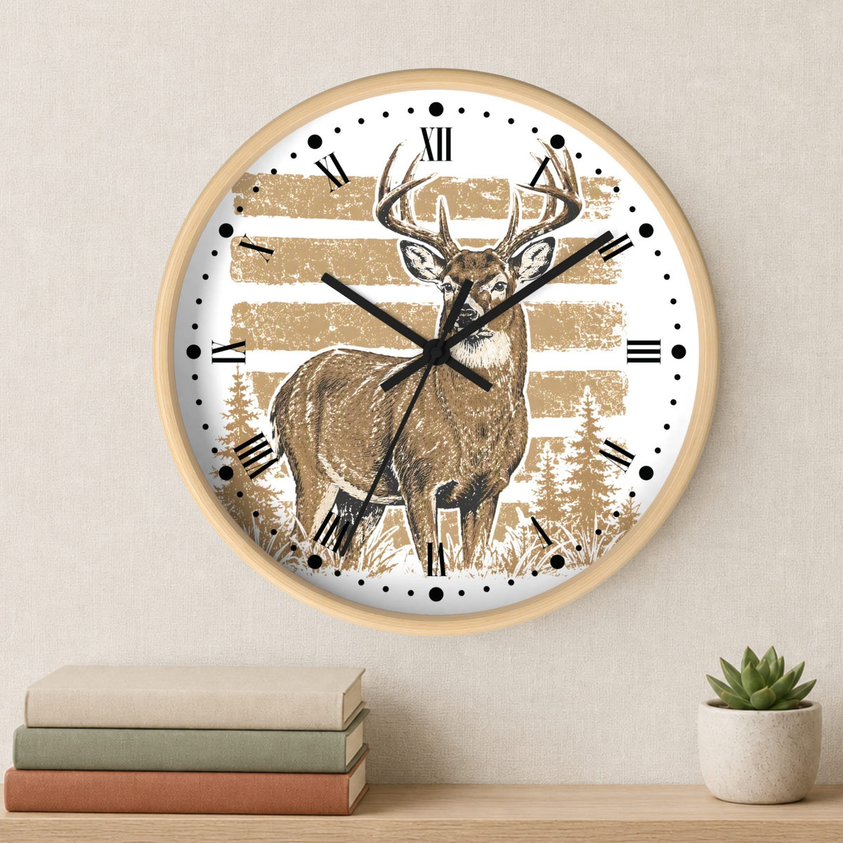 A round wall clock with a light wood frame hangs on a beige wall above a shelf with stacked books and a small potted succulent. The clock face features a brown deer illustration over a distressed tan and white striped background with black Roman numerals and black clock hands.