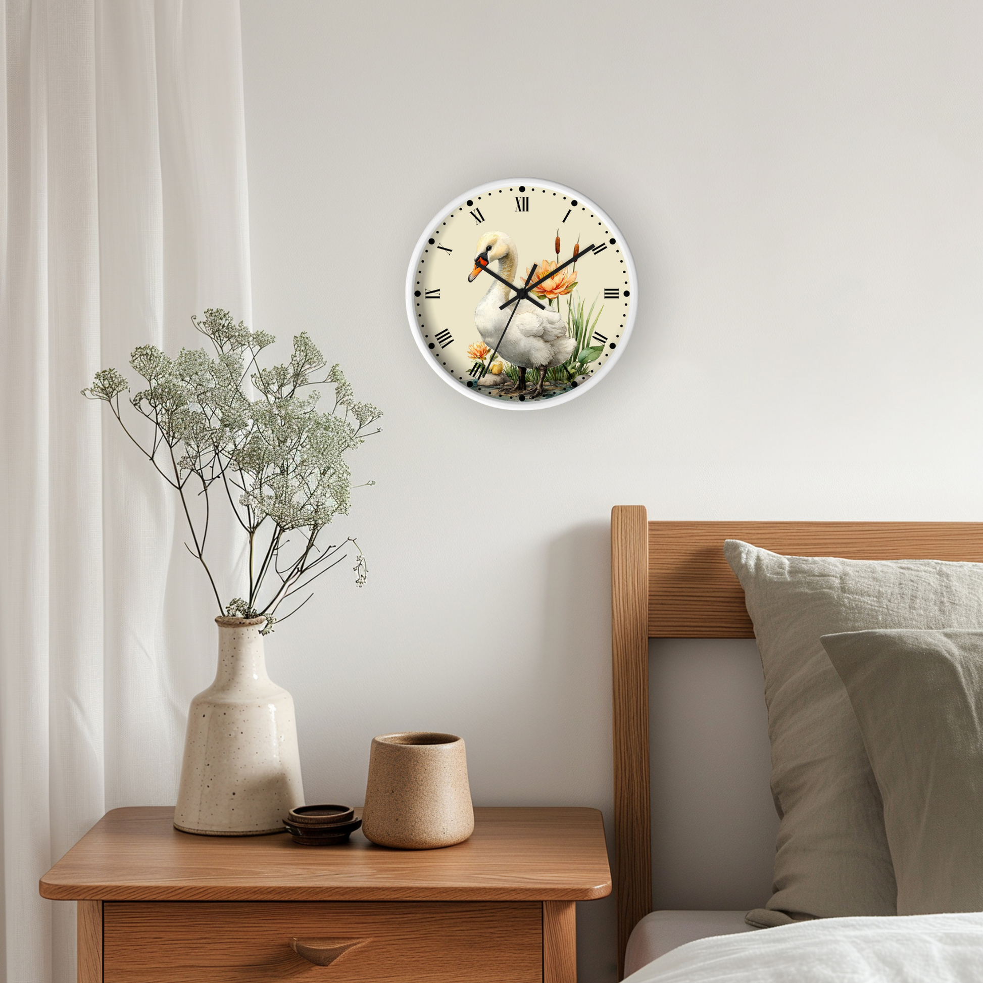A round wall clock with a white face and black Roman numerals hangs on a light gray bedroom wall above a wooden nightstand. The clock face features a printed illustration of a white duckling in a pond with orange accents.
