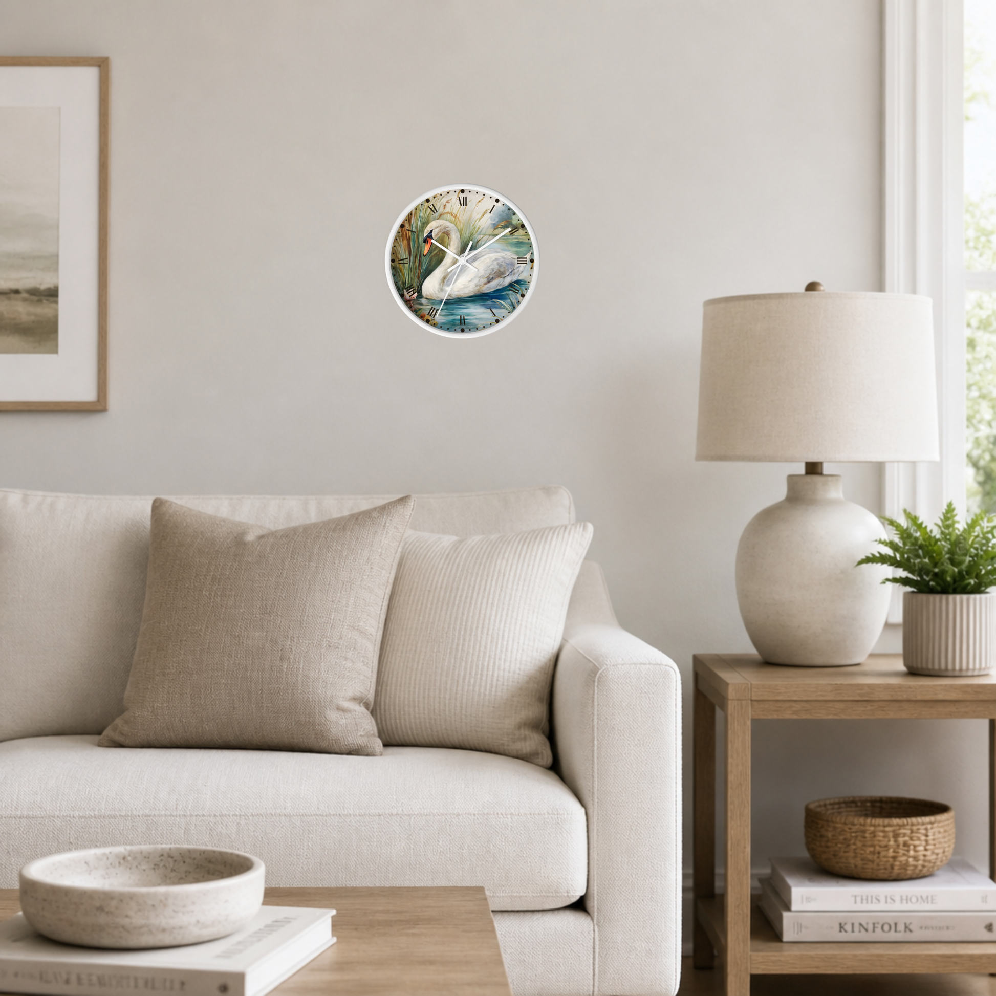 A round wall clock with a colorful floral and bird illustration, mounted on a light beige wall in a modern living room setting with a sofa, side table, and lamp.