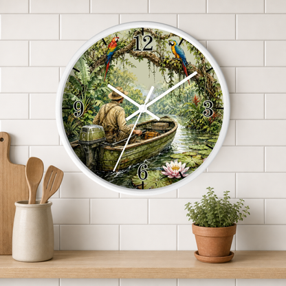 A round wall clock with a white frame hangs on a white subway-tile wall above a wooden shelf. The clock face features a printed illustration of a man in a motorboat on a river with lily pads, surrounded by colorful birds and trees.