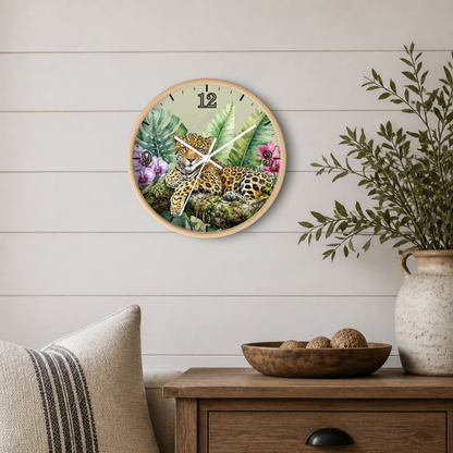 A round wall clock featuring a tropical jungle scene with a spotted big cat, displayed on a light wood-paneled wall above a wooden side table with a vase and bowl.