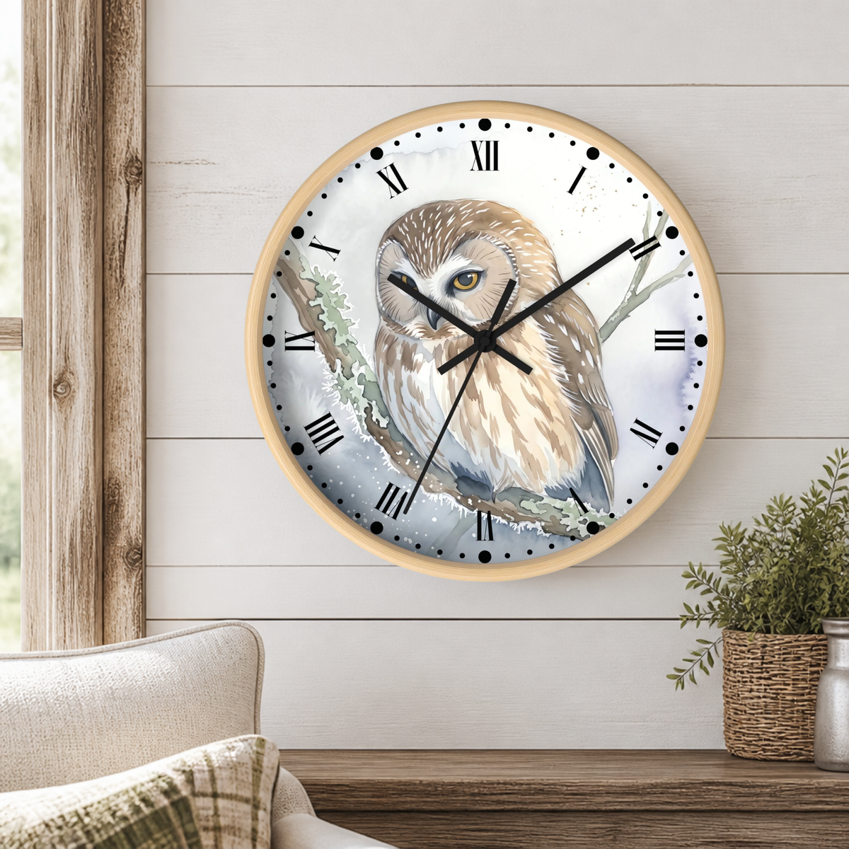 natural wood round wall clock with a watercolor illustration of a cream and brown owl perched on a branch in a winter like scene, mounted on a shiplap wall in a living room