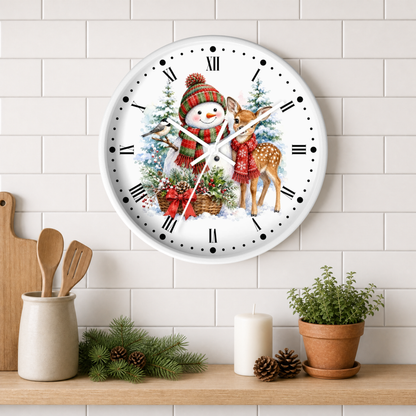 A round white wall clock with a festive Christmas illustration of a snowman and deer, styled on a light gray subway tile wall above a wooden shelf with kitchen props.