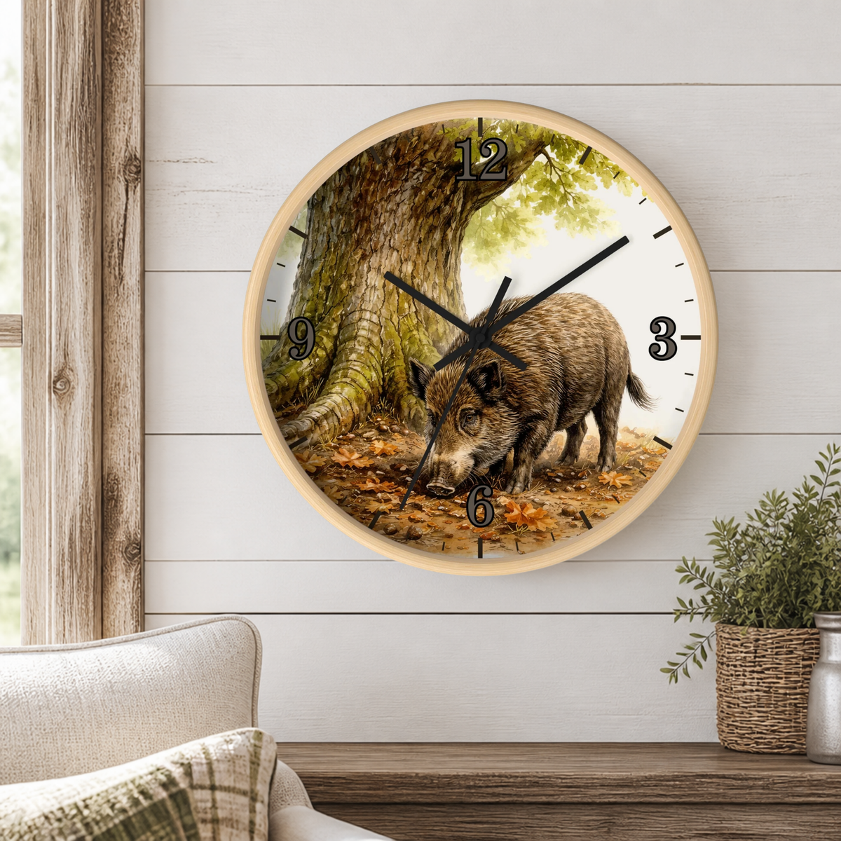 Round wall clock with a light wood frame featuring a printed wild boar in a forest scene, mounted on a white shiplap wall above a wooden mantel with a small potted plant.
