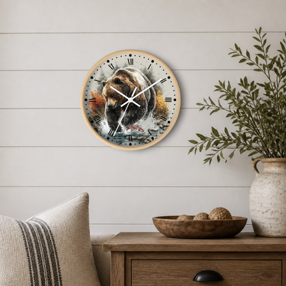 Round wall clock featuring a detailed painting of a brown bear with fish, styled on a white shiplap wall above a wooden side table with a plant and decorative bowl.