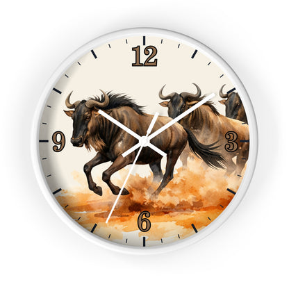 A round wall clock with a white frame and a printed design of three bison running through orange watercolor terrain. The clock face has a cream background with black hour markers and white hands.