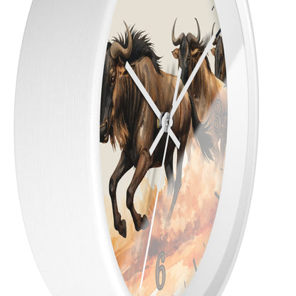 A white oval wall clock featuring a printed design of two brown wildebeest against a warm orange and beige sky, with white hands and a visible numeral 6 near the bottom.